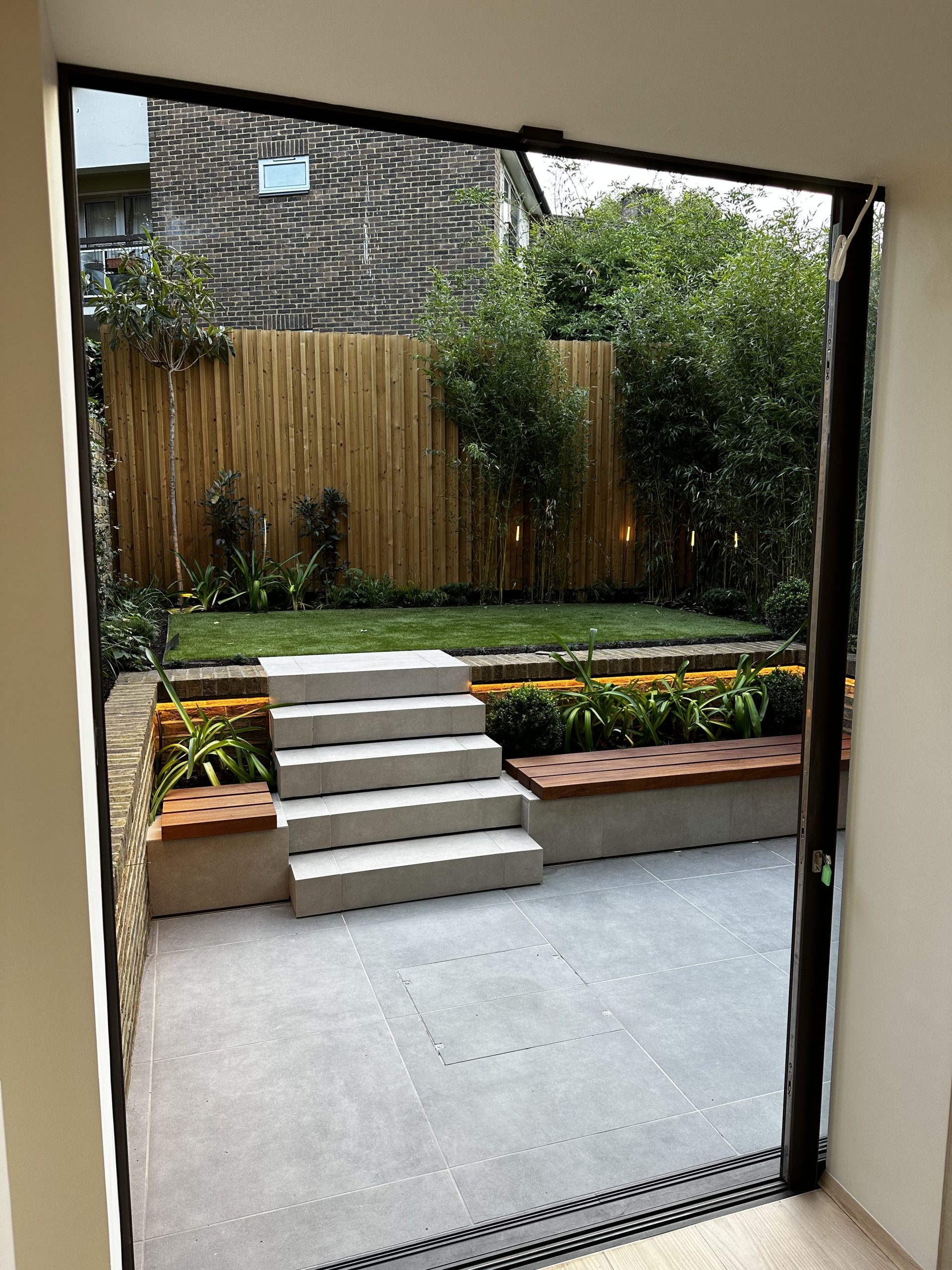 Outdoor lighting installed around a landscaped garden and patio