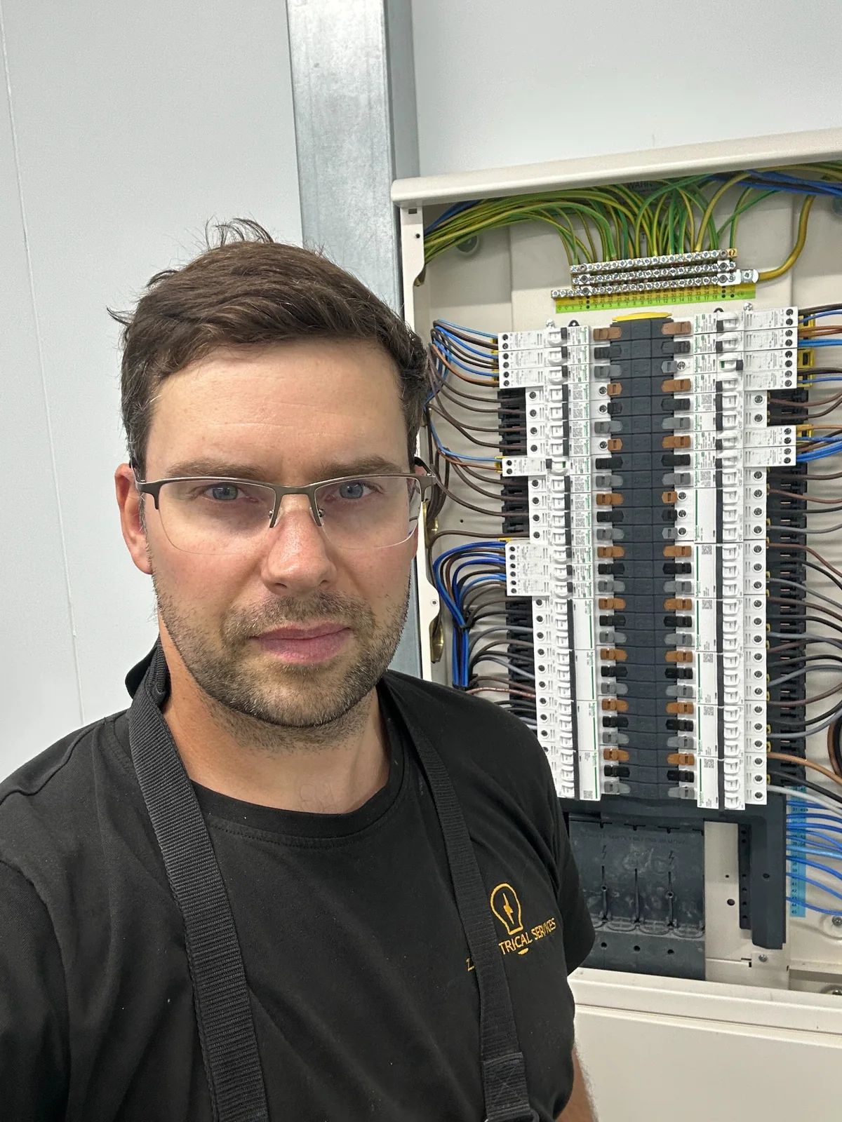 Commercial Distribution Board Installation ZJ Electrical Services electrician beside a commercial electrical distribution board