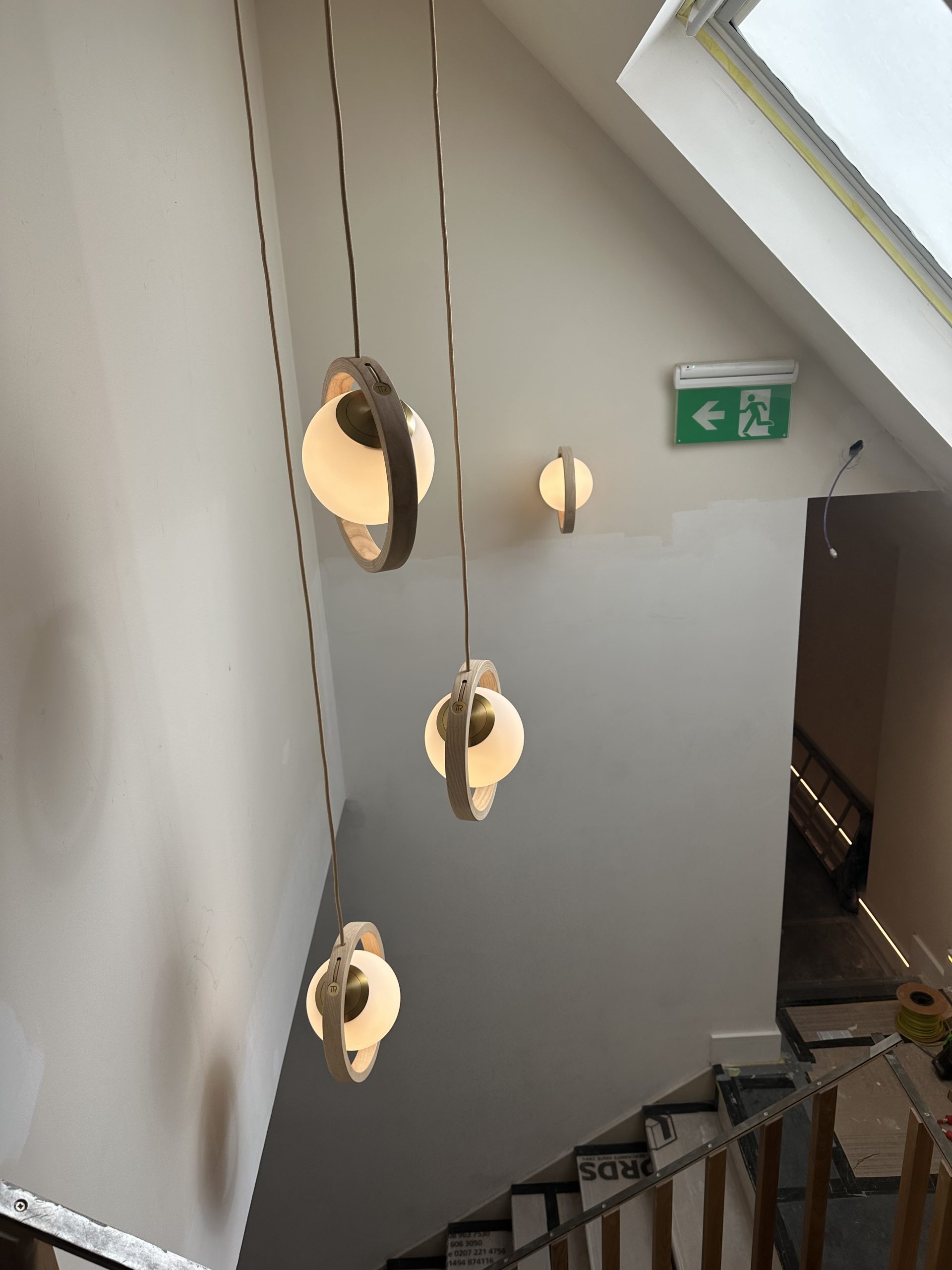 Decorative pendant and wall lights in a Pilates studio stairwell during installation
