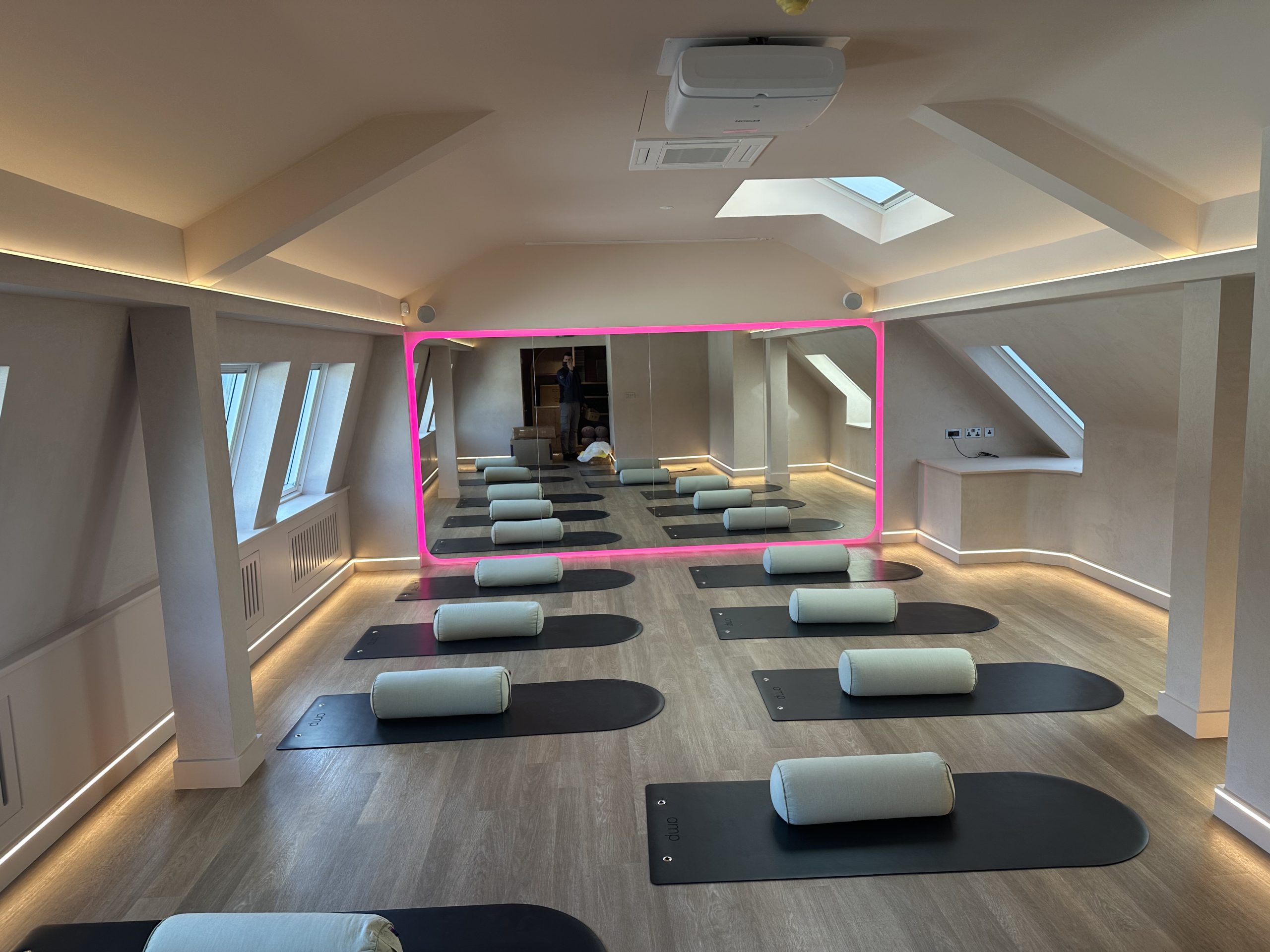 Pilates studio with ceiling perimeter lighting and illuminated mirror