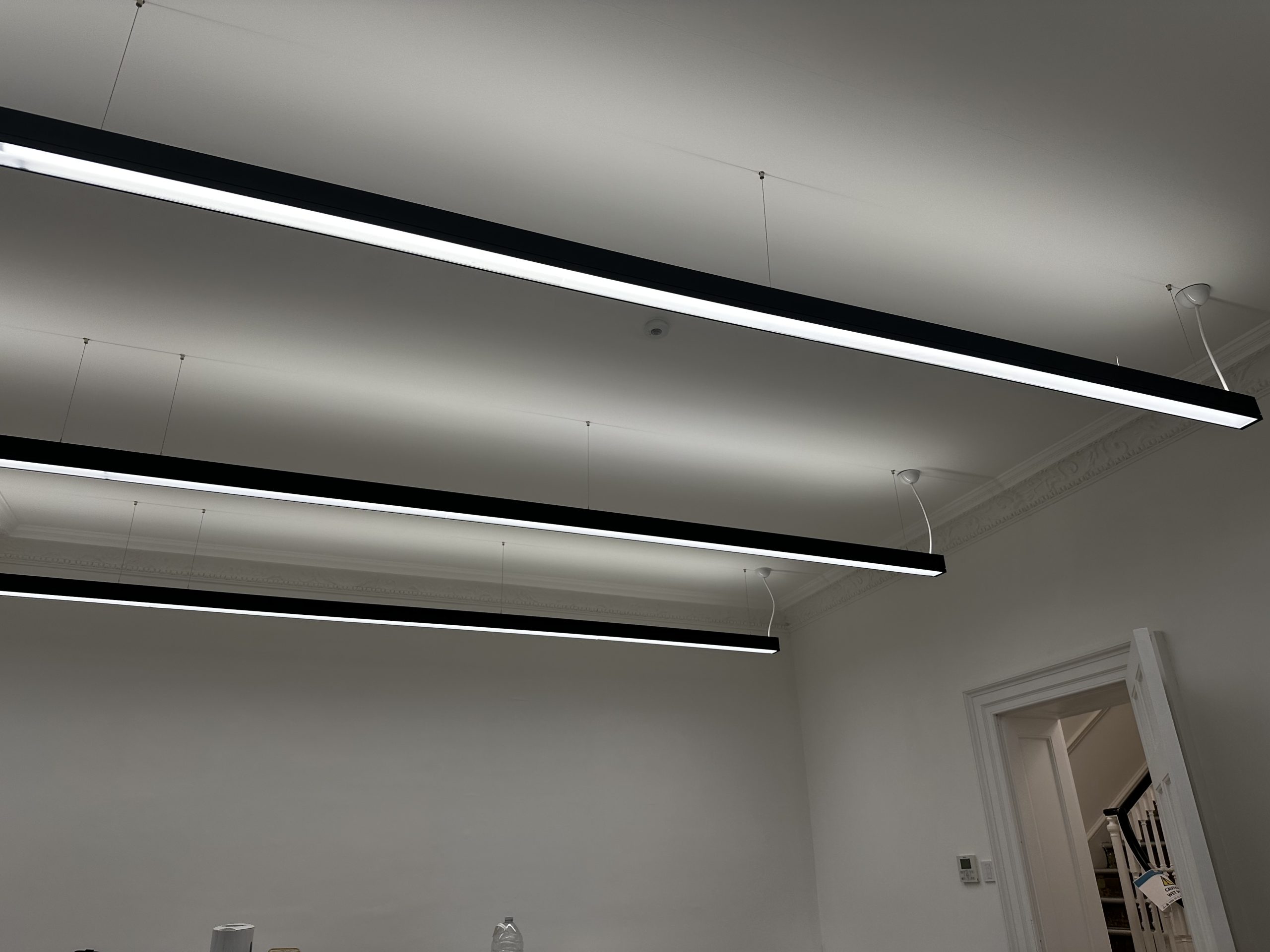 Suspended black linear lights in an office